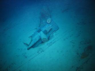 Stbd anchor embedded in steel plate from ship's side in debris field
